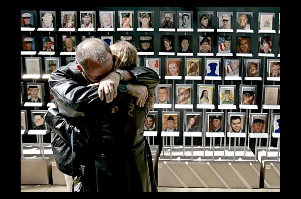 A couple from Highland, Indiana, embraces after seeing their son's portrait among the A couple from Highland, Indiana, embraces after seeing their son's portrait among the