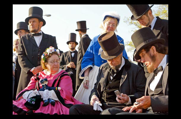 President Abraham Lincoln lookalikes and their wives examine their cell phones before the dedication of the Abraham Lincoln Presidential Library and Museum in Springfield, Ill.