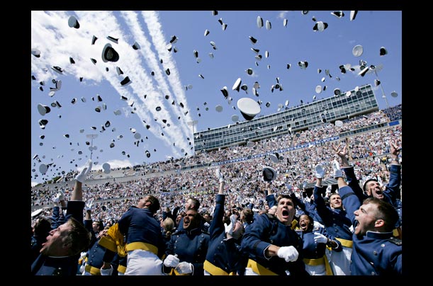 cadets celebrate their graduation from the air force academy in colorado by throwing their hats in the air