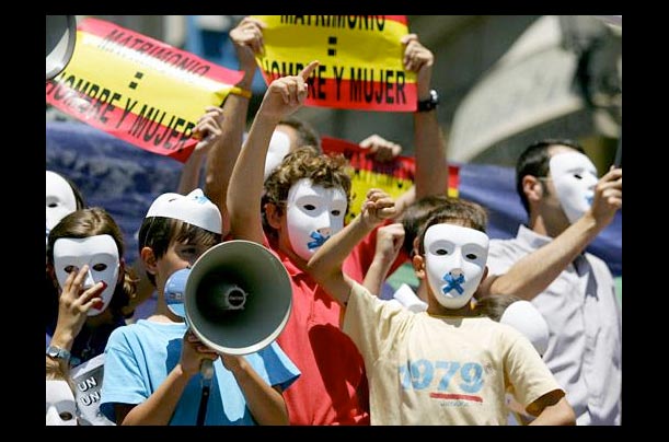 In Madrid, children wearing white masks demonstrate against Spanish parliament
