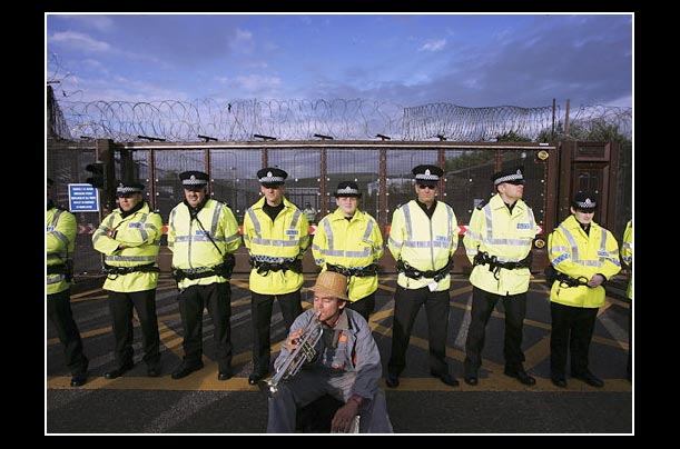 A lone protester plays trumpet next to a police line in front of Faslane Nuclear Submarine Base in Scotland A lone protester plays trumpet next to a police line in front of Faslane Nuclear Submarine Base in Scotland