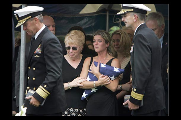 The fiancee of a Navy SEAL killed in Afghanistan receives an American flag at during funeral services in Calverton, N.Y.