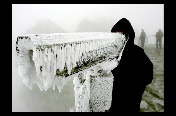 A tourist looks through an icy telescope on Zugzpitze mountain, Germany's highest peak