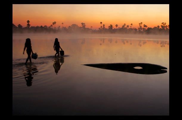 women collect water from Lake Ipatse in Kuikuro village in Amazon High Xingu park, Brazil