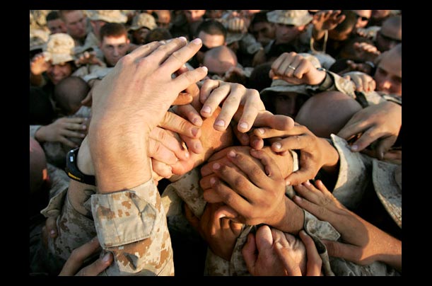 Marines of Kilo Co. 3rd Battalion 1st Marine Regiment join hands in unity before searching for insurgents in Haditha, Iraq