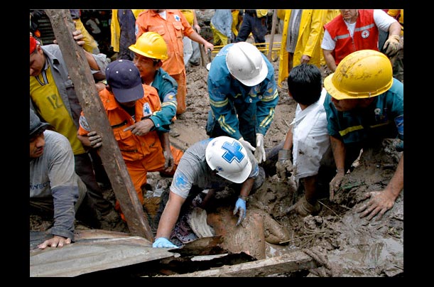 Rescue workers try to retrieve victims from a mudslide in San Salvador