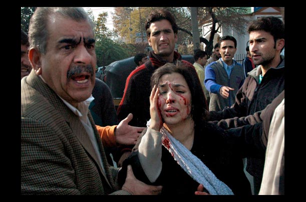 Kashmiris assist an injured woman after a car bomb set off by Islamist militants in central Srinagar, capital of Indian-held Kashmir