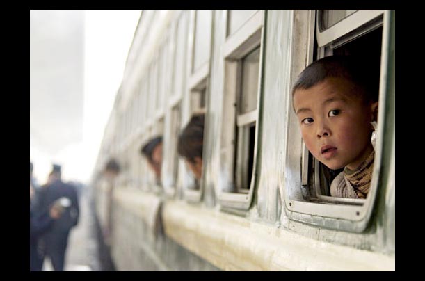 A boy waits for his train to leave from Zhengzhou railway station to Chun Yun in china