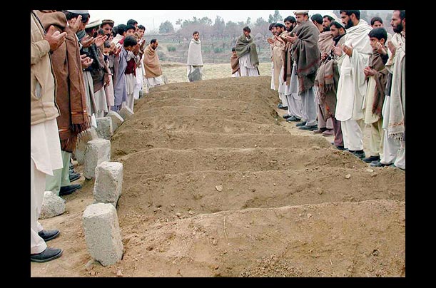 Tribesmen pray at the graves of some of those killed in a missile strike believed to have come from a U.S. drone