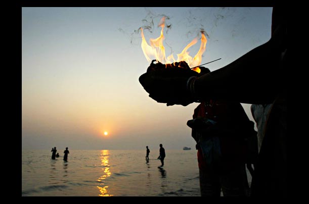 Hindu pilgrims wade in the water at Gangasagar, the confluence of River Ganges and Bay of Bengal
