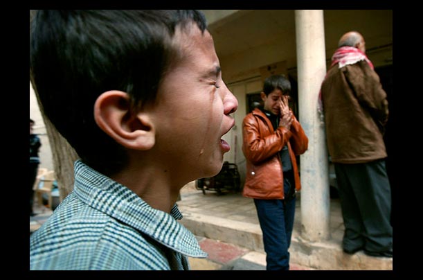 Boys mourn the death of university professor and political analyst Abdul-Razzaq al-Na'as during a funeral procession in Baghdad