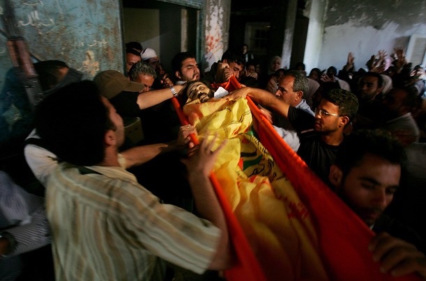 Palestinian mourners carry the body of pro-Fatah commander