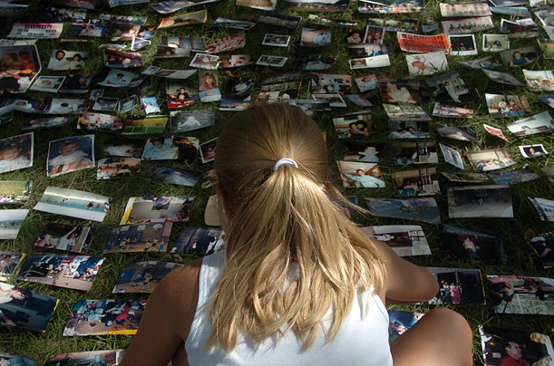 Chloe, 9, organizes photos to dry in the front yard of Glen Cease's house after they were damaged by a flood in Ottawa, Ohio.
