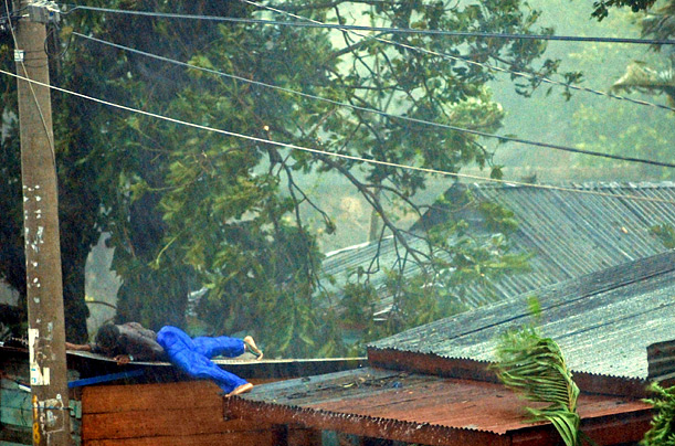 A man holds to the roof of his house during the arrival of category five hurricane Felix in Puerto Cabezas, Nicaragua.