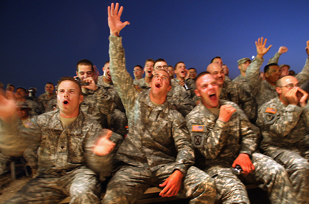 American soldiers cheer as the Dallas Cowboy cheerleaders take the stage during a military USO tour in Baghdad.

