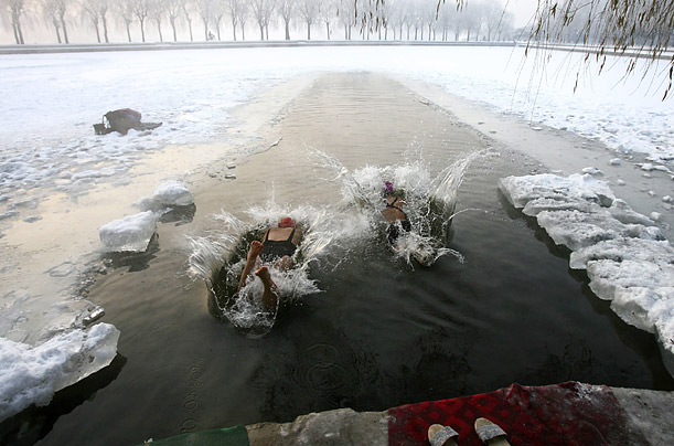 Winter swimmers jump into icy water during the early morning at a park in Shenyang, Liaoning province, China.