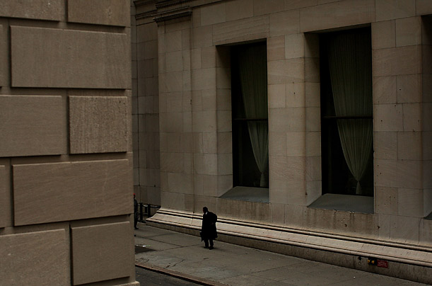 A man walks down Wall Street, following a sharp fall in international markets Monday.