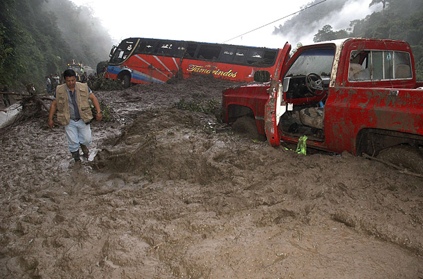 A passenger bus is trapped in debris as a journalist arrives at the site of a mudslide in Mancha Grande zone, Manabi province in Ecuador.