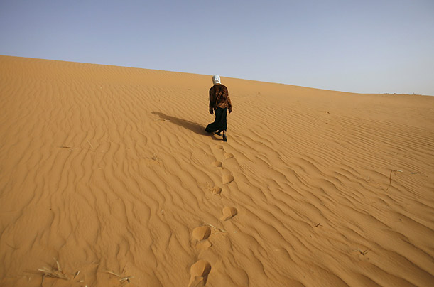 A girl walks near Ouled Said ksar, a fortified village on the outskirts of the oasis town of Timimoun, Algeria.