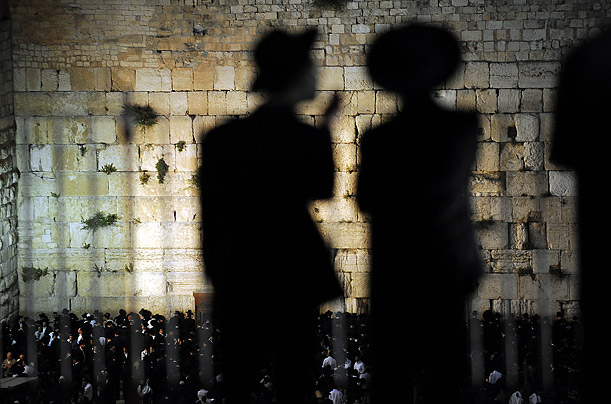 Ultra Orthodox Jews watch worshippers pray in front of the Wailing Wall in Jerusalem. Israel celebrates its independence on May 14.