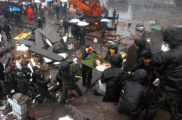 Rescuers carry a student out of the debris of a collapsed middle school at the earthquake-affected Yinghua Township in Shenfang, southwest of Sichuan province. 
