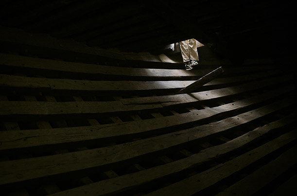 An Indonesian worker leaves the hull of a wooden ship after loading it with cement in Jakarta's port.