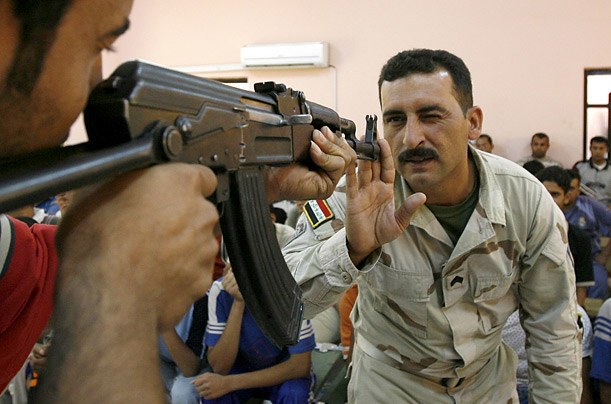 An Iraqi soldier teaches a Neighborhood Guard recruit how to aim a rifle during training at a U.S. military base in Baghdad.

