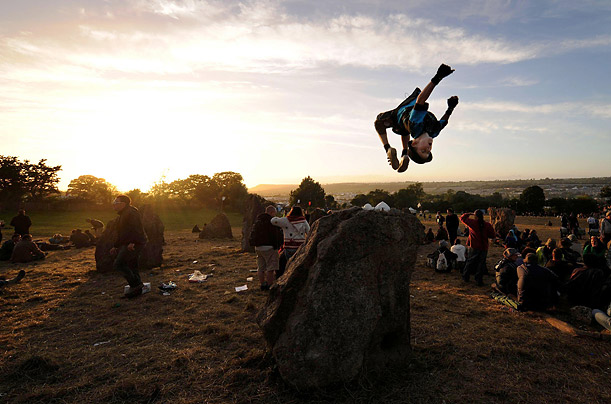12-year-old Elliott Hatchett from London performs back-flips in the stone circle at sunset on the final day of the 2008 Glastonbury Festival, Somerset, England.