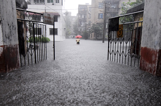 A resident walks through a flooded residential area in Xiangfan, Hubei province, China.  



