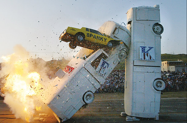 Stuntman Spanky Spangler pilots his airborne car into two old buses standing end on end to create a domino effect, during Evel Knievel Days in Butte, Mont.