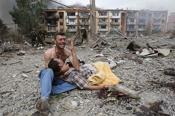 A Georgian man cries near the body of his relative after a bombardment in Gori, where Russian warplane dropped a bomb on an apartment block.