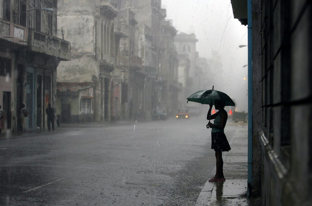 A woman covers herself from heavy rains caused by approaching Hurricane Gustav in Havana, Cuba.