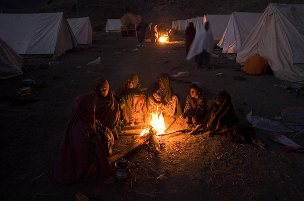 Pakistanis warm themselves next to a fire in a camp for people displaced by an earthquake that struck near Quetta, killing more than 200 people.

