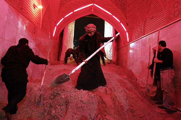 Shiite Muslims shovel sand on the floor of an entrance to the shrine of Imam Abbas to prevent pilgrims from slipping and falling during the Ashura mourning period in Karbala, Iraq.
Shiite Muslims shovel sand on the floor of an entrance to the shrine of Imam Abbas to prevent pilgrims from slipping and falling during the Ashura mourning period in Karbala, Iraq.