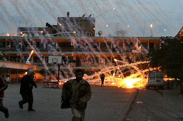 Palestinian civilians and medics run to safety during an Israeli strike over a UN school in Beit Lahia, northern Gaza Strip