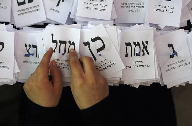 An election official holds a ballot for the Likud party while tallying votes at the Knesset, Israel's parliament, in Jerusalem.

