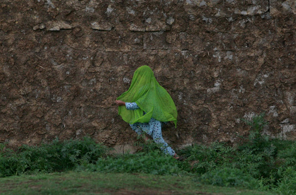 An Afghan girl runs along a dirt path in her village on the outskirts of Islamabad, Pakistan.