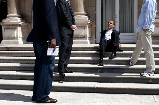 U.S. President Barack Obama talks to aides as he sits on the steps of the U.S. Ambassador's residence in Paris.