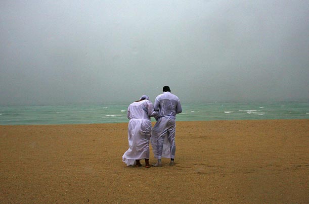 Cindy and Donald Eugene pray at the beach under heavy rain in Miami Beach, Florida.