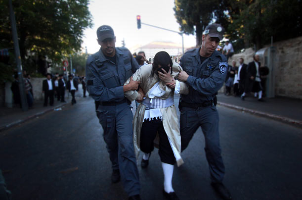 A protester is led away from a protest in Jerusalem as ultra-Orthodox Jews clashed with security forces during a demonstration