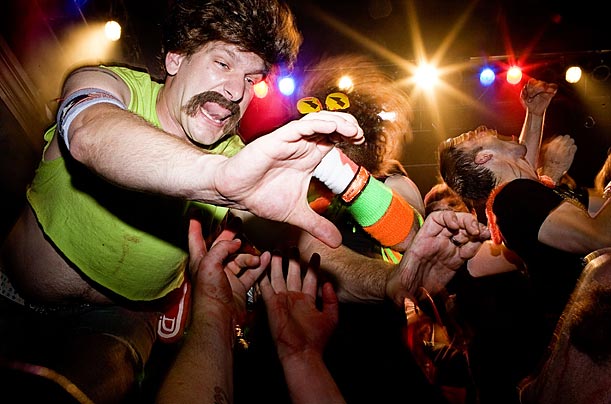 A performer reaches out to the audience during a free-for-all collaborative air guitar rendition of the song 