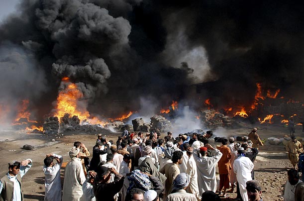 People watch as a fire erupts in the main market in Quetta, Pakistan. About one hundred shops were damaged and four people sustained injuries in the blaze.