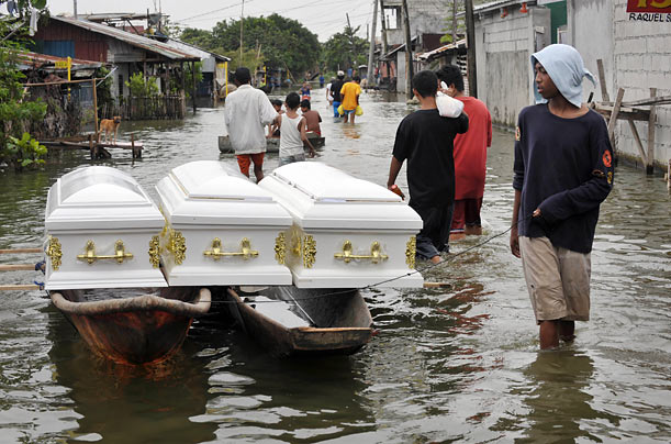 Sorrow
A boatman transports three empty wooden coffins near Laguna Lake in the flood-ravaged Philippines.