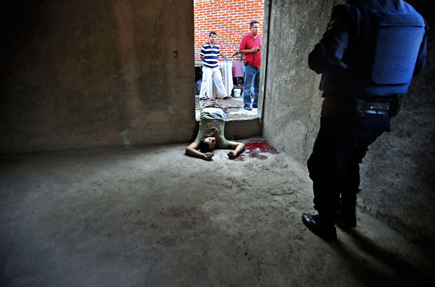 Live By The Sword
Police in Uruapan, Mexico, survey the scene of a shootout between rival gangs.