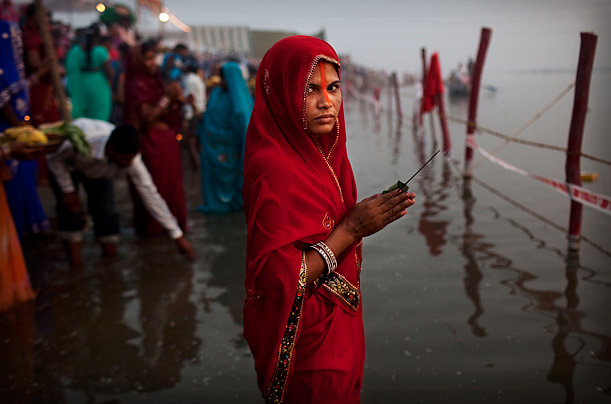 An Indian woman from the state of Bihar holds incense as she offers prayers in the Yamuna River on the Hindu holiday of Chaath Puja in New Delhi. On Chhath, an ancient Hindu festival, rituals